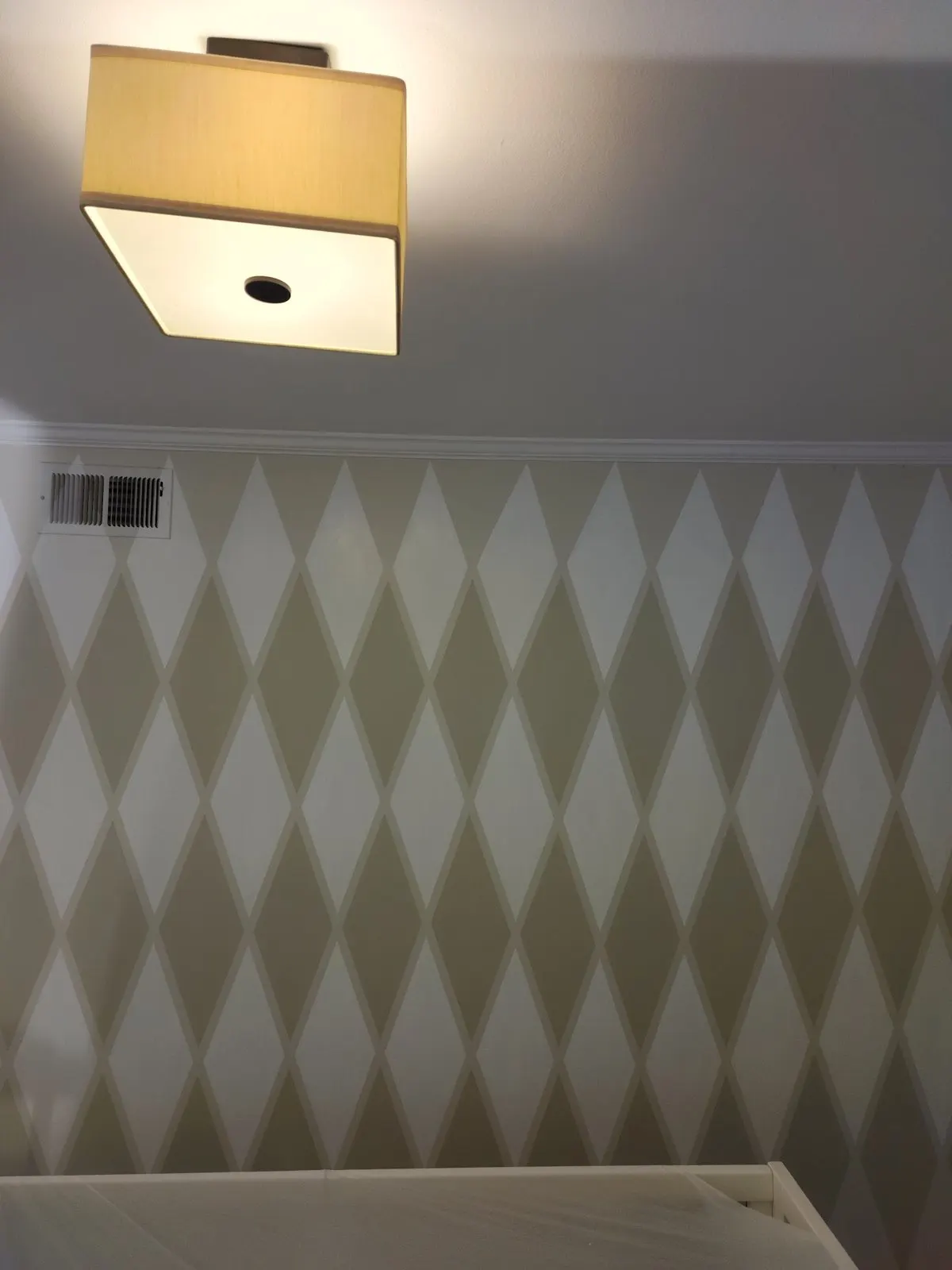 Diamond accent wall under a ceiling light
