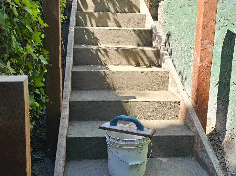 Long run of outdoor concrete steps freshly formed and finished between wood forms