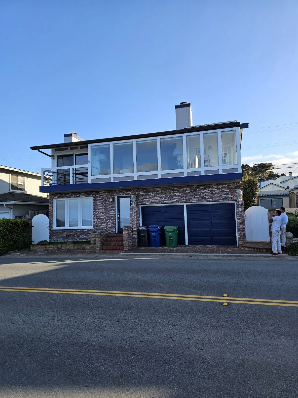 Two-story exterior with navy trim and garage doors
