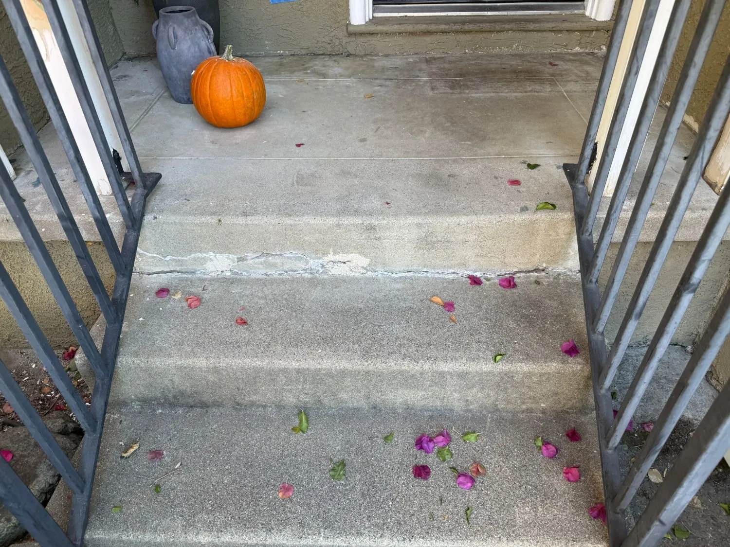 Concrete front steps with the crack along the step filled