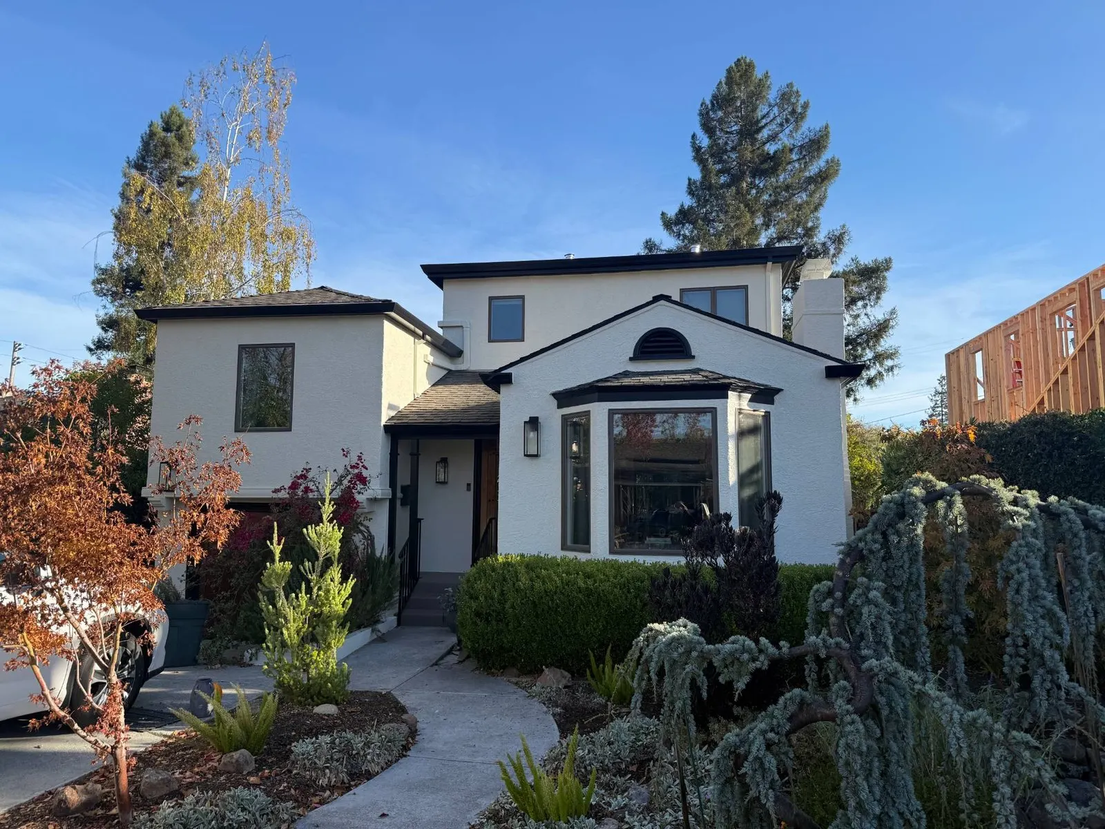 Two-story stucco house painted white with black trim